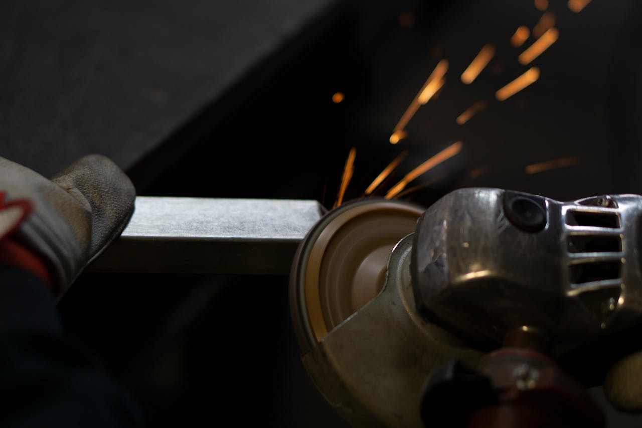 services-04 Angle grinder working on steel, emitting bright sparks. Industrial close-up shot.